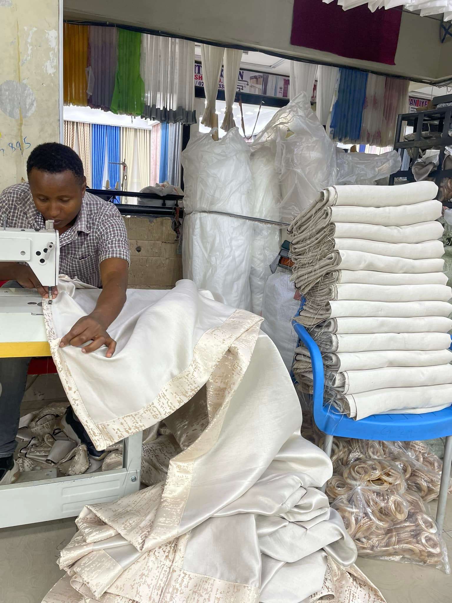 Tailor sewing custom curtain fabric at Zimark Curtain workshop in Nairobi.
